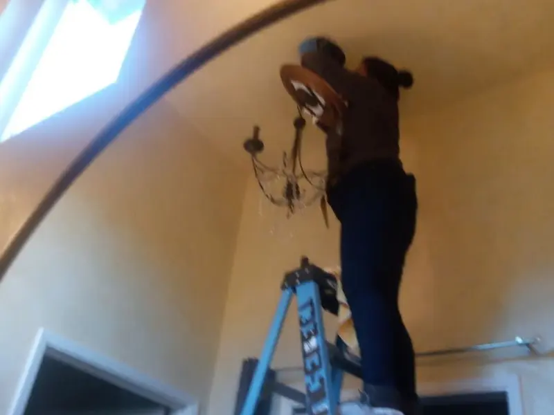 Electrician installing a chandelier in a Glendale residence
